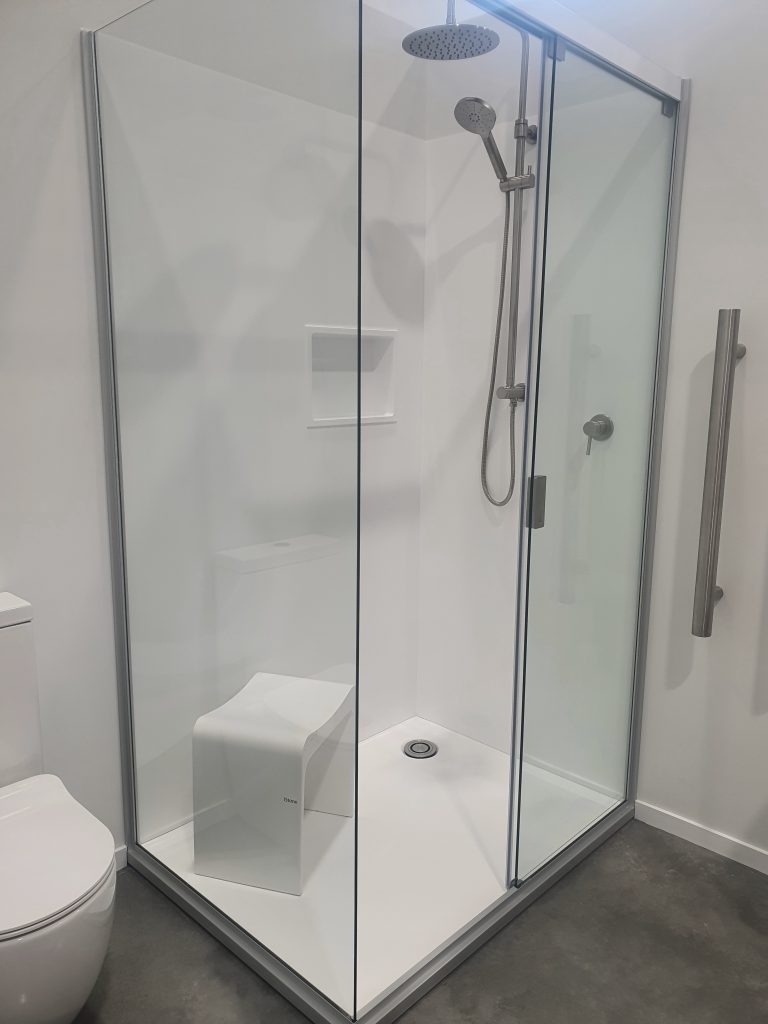 This Atlantis acrylic shower has a low-profile base with corner drain, sliding door, frameless glass and acrylic niche. 