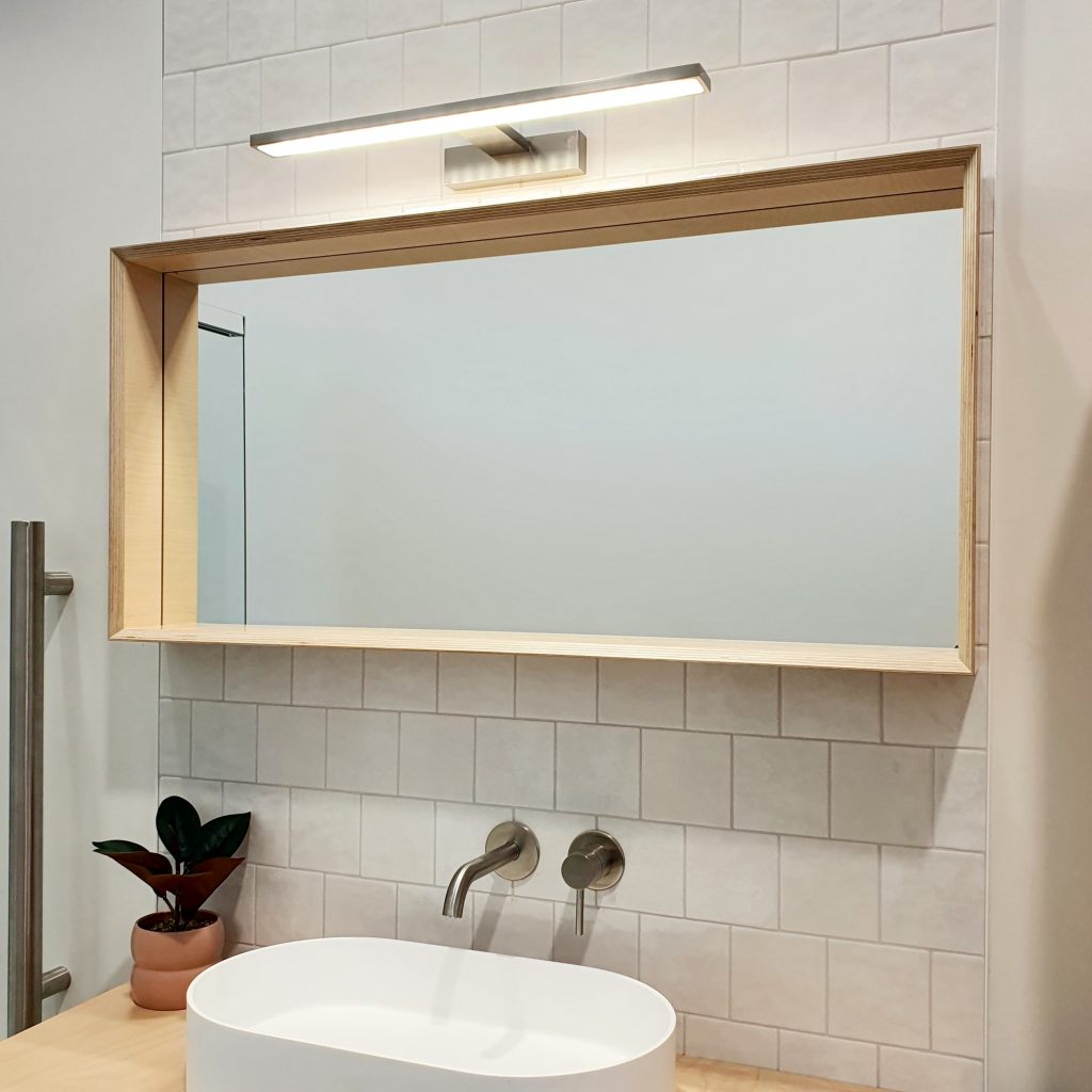 Ply design mirror with vanity light installed into our Bay Bathroom Design and Build showroom in Tauriko