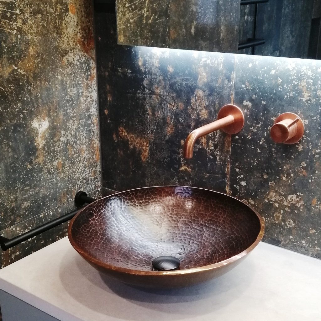 LED strip lighting under a mirror cabinet helps to show off this beautiful copper tapware and beaten effect vessel basin